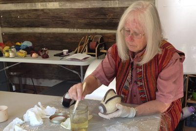 Cheri Miller applying natural shellac as stiffiner as a finishing technique for her well fulled form. STRONGFELT STUDIO workshop, Asheville, NC 2014.