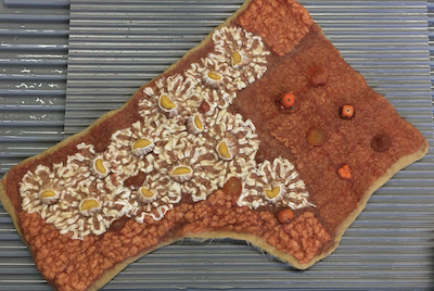 Sibel Adlai's project of a handbag flap entrapping beads as well as partial felt as a texture resist in the center of the fabric's daisies. Depth of Surface/Depth of Field at  Eva Camacho Sanchez's Studio 2020.