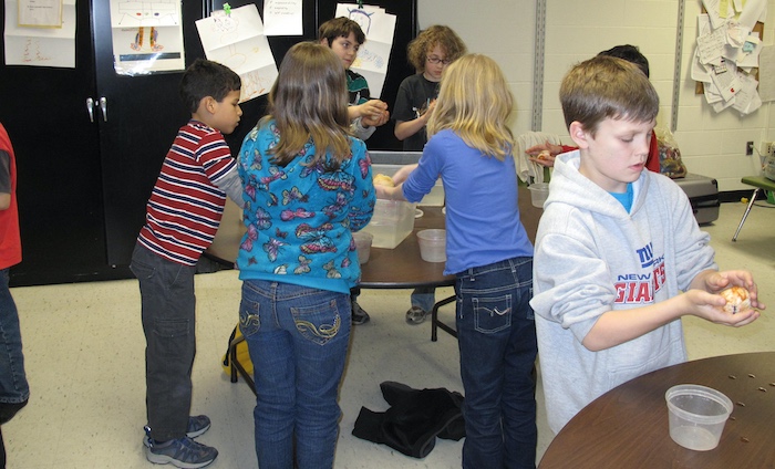 Students gently clasping their fiber covered balloons for the first dip in soapy water