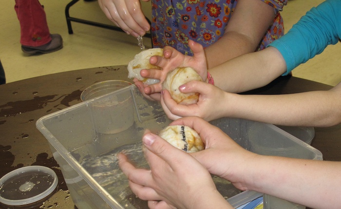 Gently passing the egg back and forth between their hands to begin the integration of the exterior wool fibers