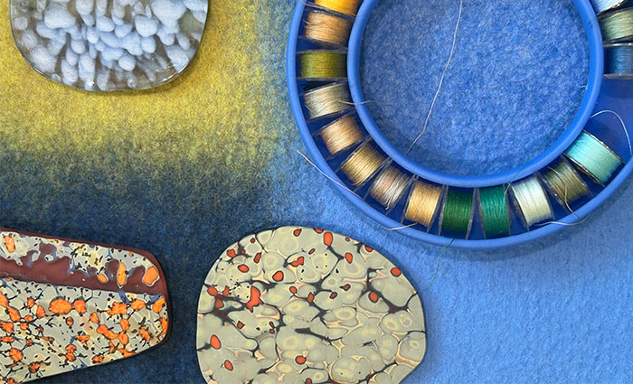 Creating partial felt to compliment the colors of your object and cutting out the bezel frame inspired by the shape of your object and its surface patterns before applying free-motion machine stitching